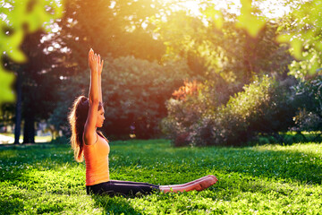 Yoga. Young woman practicing yoga or dancing or stretching in nature at park. Health lifestyle concept