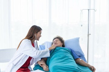 Obraz premium A young beautiful doctor is checking an old patient woman.