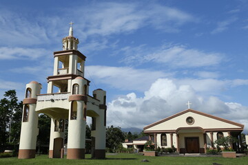 Fototapeta na wymiar Kirche und Glockenturm, St. Raphael der Erzengel in Tigaon, Camarines Süd, Philippinen