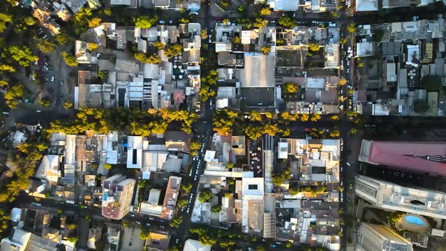 Aerial top down truck right over Santiago city residential area houses and traffic in avenues at golden hour, Chile