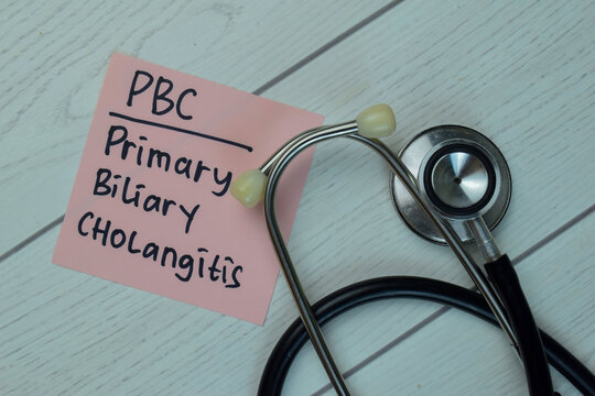 PBC - Primary Biliary Cholangitis write on sticky notes isolated on Wooden Table. Medical concept