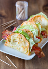 A small platter of provolone crisp appetizer wraps, ready for eating.