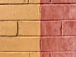 Orange yellow painted  sun drenched weathered brick wall
