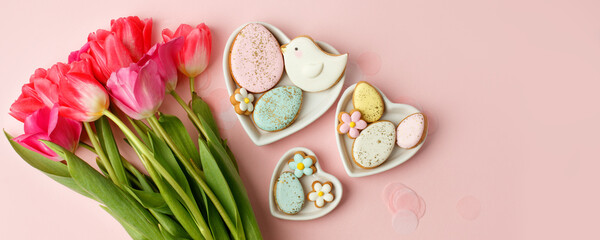 Fototapeta na wymiar Easter floral background, various gingerbread glazed cookies end decorated with natural botanical elements on pink, flat lay, view from above, blank space for greeting text, banner, flyer, coupon