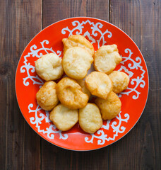 National Kazakh pastries baursaks in a plate on a wooden background