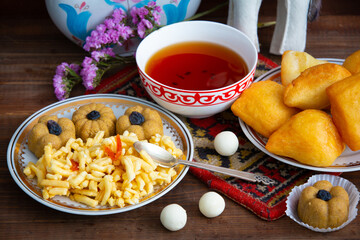 Kazakh still life on Nauryz, with national food: baursaks, zhent, kurt, chak chak and tea on a...