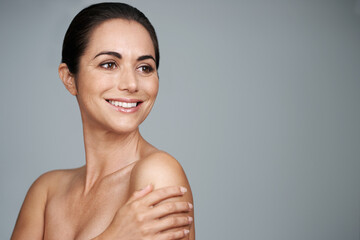 Her skin still looks and feels beautiful. Studio shot of a beautiful mature woman standing with her...