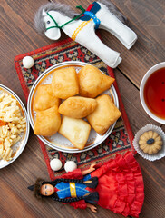 Kazakh still life on Nauryz, with national food: baursaks, zhent, kurt, chak chak and tea on a wooden background