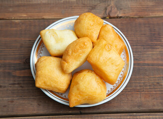 National Kazakh pastries baursaki in a plate on a wooden background