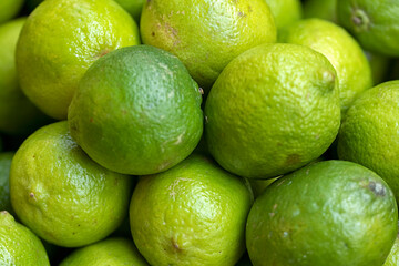 Closeup of fresh limes on greengrocers stall at a farmers market