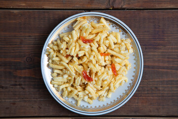 Traditional oriental sweet dessert chak-chak with dried apricots in a plate on a wooden background