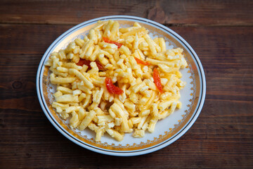 Traditional oriental sweet dessert chak-chak with dried apricots in a plate on a wooden background
