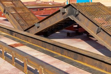 Metal structures at the industrial site prepared for processing and painting. An industrial enterprise producing building metal structures.
