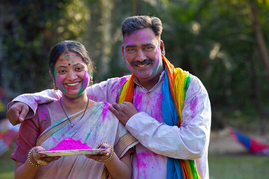 Portrait of middle aged couple with colourful faces on Holi