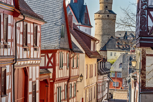 Fachwerkh&auml;user in einer Reihe mit einem alten Stadtturm im Hintergrund in der Altsatdt von Idstein im Taunus, Hessen, Deutschland