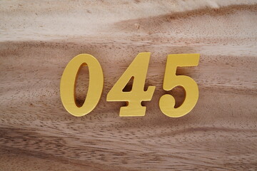 Golden Arabic numerals on a real brown and white wooden floor number 045