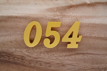 Golden Arabic numerals on a real brown and white wooden floor number 054
