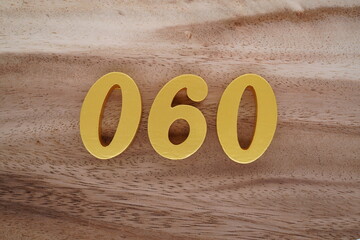 Golden Arabic numerals on a real brown and white wooden floor number 060