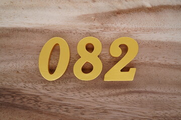 Golden Arabic numerals on a real brown and white wooden floor number 082