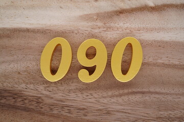 Golden Arabic numerals on a real brown and white wooden floor number 090