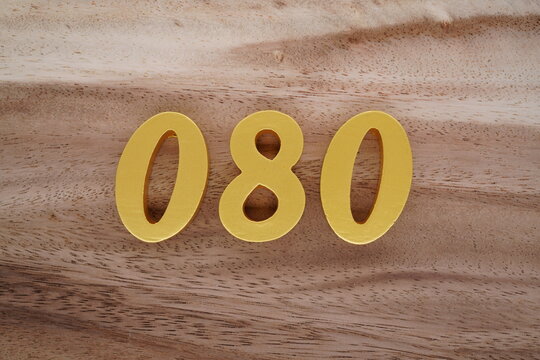 Golden Arabic numerals on a real brown and white wooden floor number 080