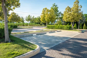 Foto op Canvas Empty space in city park outdoor concrete parking lot area with blue sky in summer season. Green nature gardening in car parking lot. Friendly environmental and transportation concept. © pla2na