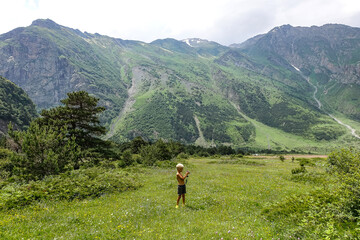 Fototapeta na wymiar A boy in the gorge of the Cherek River in the vicinity of the Ushtulu tract. Caucasus 2021