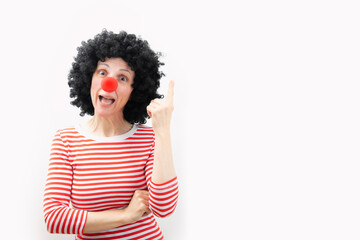 woman with a clown nose pointing with her hands. surprised face. white background. copy space
