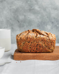 whole wheat gluten free bread with flax seads sunflower chia seads sesame on gay stone back grown with white linen napkin. side view with copyspace