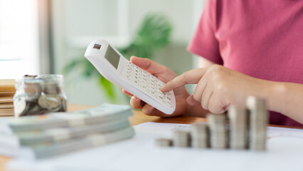 Saving concept the woman in a red top calculating monthly expense and income by using the calculator