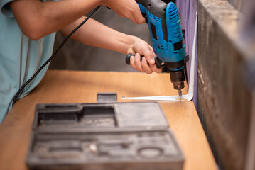 Boy teenager use screwdriver fix wood table