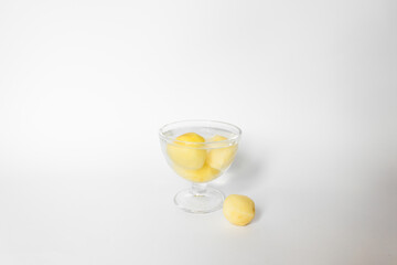 Glass bowl of water with raw peeled potato vegetables. Isolated on white background.