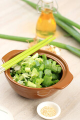Bowl of chopped spring onions with Oil and Sesame Seed,