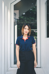 Happy asian woman standing outdoors in casual blue t shirt against cafe.