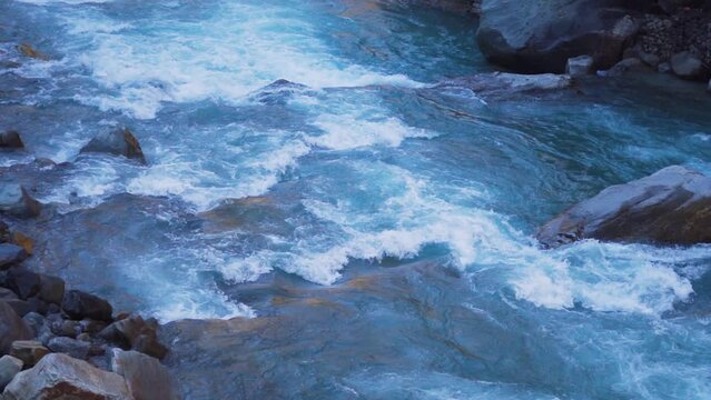 Slow motion shot of the Paravti River flowing in between mountains at Manikaran near Kasol in Himachal Pradesh, India. View of the Parvati river during the winter. Natural river in the mountains.