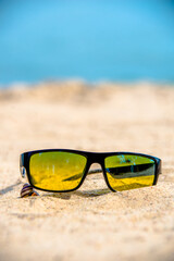 Sunglasses are lying on the sea beach
