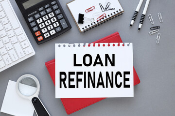 Loan Refinance. gray background top view. white keyboard, calculator. text in an open notebook