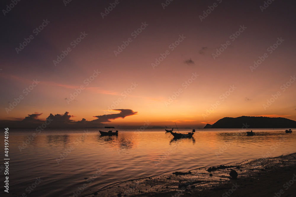 Wall mural silhouettes of fishing boats on the sea at a beautiful sunset