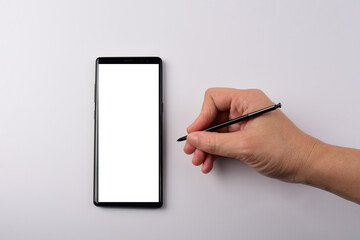 Hand and smartphone with blank white screen and black stylus for writing isolated on white...