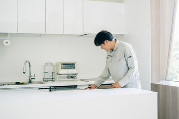 キッチンと作業着姿の男性（食洗機）
