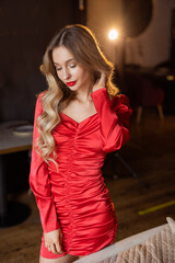 portrait of an elegant female in a red dress in a restaurant	