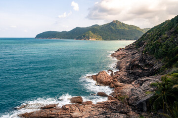 Wild place, stone shore, top view, turquoise sea waves at sunset