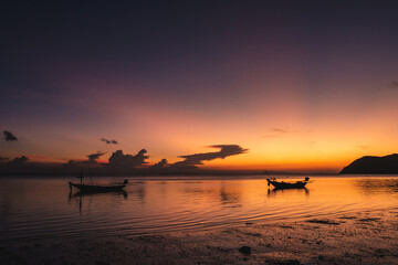 Naklejka na ściany i meble Silhouettes of fishing boats on the sea at a beautiful sunset