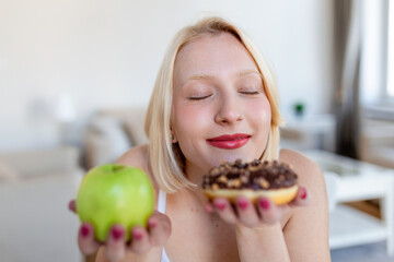 What to choose Healthy or unhealthy. Portrait of a beautiful young woman choosing between an apple or a donut