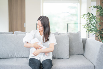 ソファーで赤ちゃんを抱っこする女性

