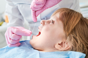 Obraz na płótnie Canvas Children dentistry. Litle girl an dentist examination, teeth cleaning and treatment.