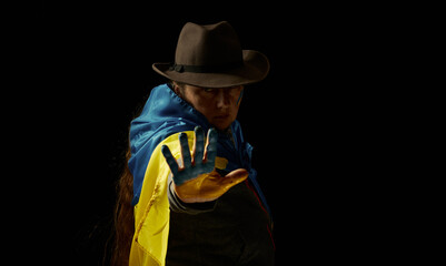 Anonimous pritty adult woman with Ukrainian flag with black background. Stop war in Ukraine..