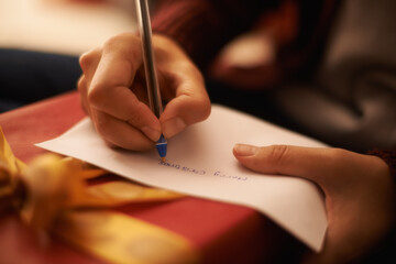 Naklejka premium All I want for christmas.... Closeup shot of a woman writing a christmas letter.