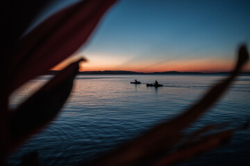 Sunset over Victoria's Lake in Tanzania, two boats sail on calm water