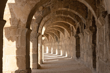 Fototapeta na wymiar Light and shadow in ancient building with many arches in it